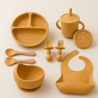 Yellow Set silicone baby feeding set with bowl, plate, bib, cup and utensils on ivory