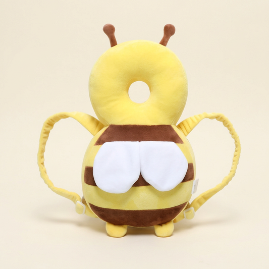 Yellow and brown Little Bee plush backpack pillow with white wings and yellow shoulder straps on warm ivory