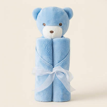 Blue bear baby blanket with white ribbon on an ivory background